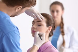 doctor drawing on patients face